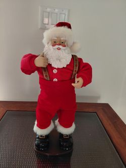 The Jingle Bell Rock Santa Claus Animated Dancing Musical from 1998 is a charming collectible figurine perfect for Christmas decor. This singing and d
