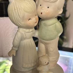 a small mechanically wind-up musical figurine that rotates around its axis