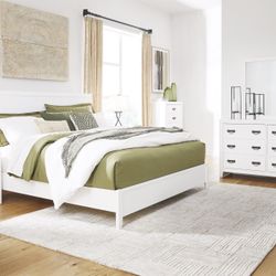 4pc Queen Panel Bed with Mirrored Dresser and Nightstand set by Ashley 
