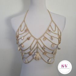 Gold chain body jewelry adorned with shell decor.
