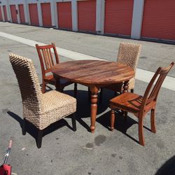 solid wood table with 2 wooden chairs and 2 covered chairs in excellent condition