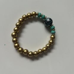 gold-toned beaded stretch bracelet featuring turquoise-colored and dark mottled beads