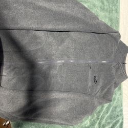 Puma branded fleece jacket featuring a chest zipper pocket.