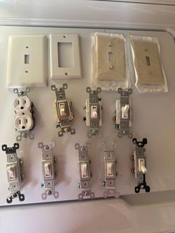 Assorted light switch covers, wall plates, duplex outlets, and toggle light switches