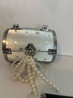 silver-toned, star-patterned cylindrical bag. Chain strap 6x 4.5” few small dirty patches. See pics. Sanitized