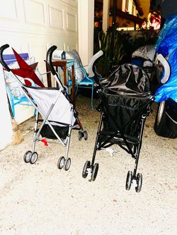 Two umbrella fold up strollers one with a son cover one without