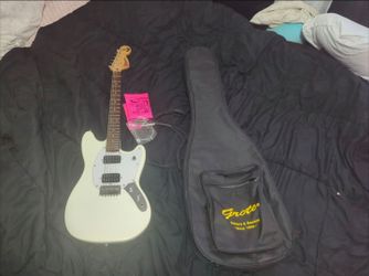 Squier Mustang HH electric guitar, 2 9 gauge strings,a backpack/carry soft case, and a 6 foot cable