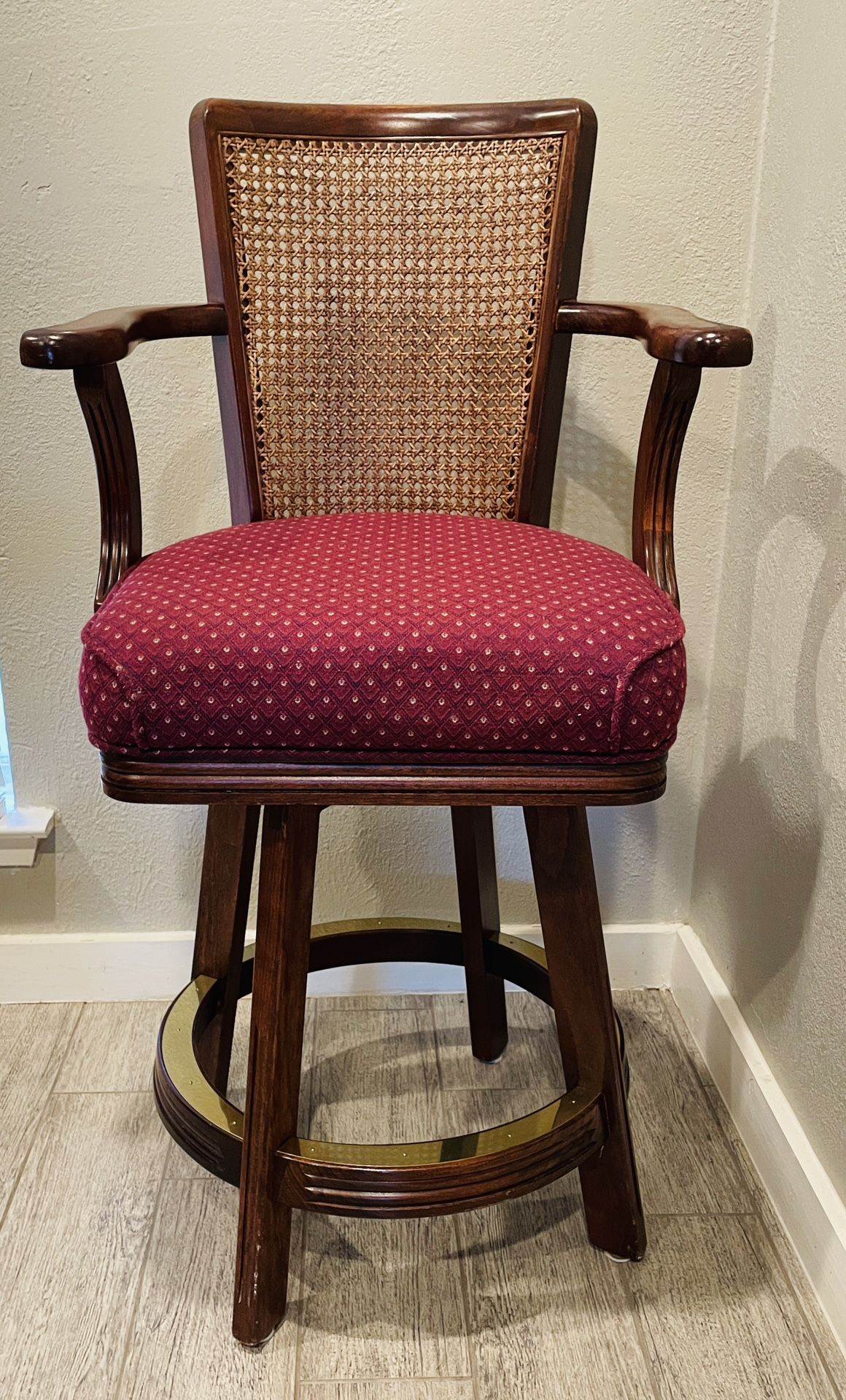 Wood Swivel Bar Stool with Arms – 26” Seat Height Sturdy bar stool with cane back, red cushion, and swivel design.