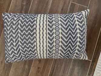 textured blue and ivory tribal geometric lumbar pillow featuring a woven chevron and patterned stripe design.