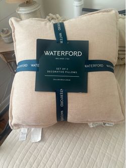 Two decorative pillows, light pink color. Bed
