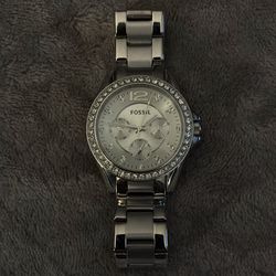 Fossil Riley Multifunction Stainless Steel Watch (model ES3202), featuring a silver dial, crystal-accented bezel, and a 38mm stainless steel case.