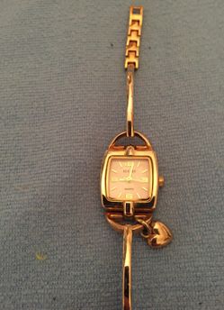 Decade gold tone watch with heart charm