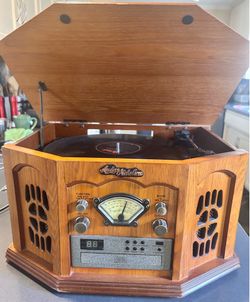 Anders Nicholson Record Player, Cd, Cassette, Radio Combo. Wood Grain console CD player, AM/FM RADIO, Cassette and 3-Speed turntable stereo.