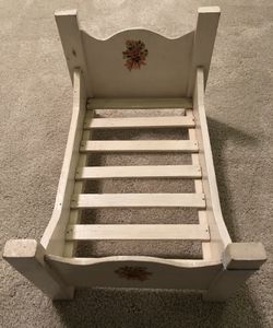 White Wooden Children’s Doll Baby Bed. 16 inches long by 11 inches wide by 10 inches tall.