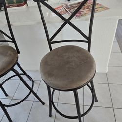 Set of 2 bar stools with metal frames and cushioned seats.