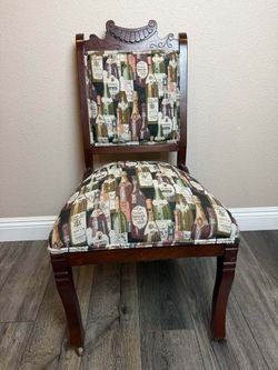 Antique Hand Carved Wood Accent Chair with Vintage Wine Bottle Upholstery & Front Casters