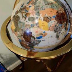 Mother of pearl and gemstone globe in brass tripod stand