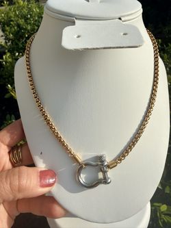Gold and silver links and a contrasting horseshoe shackle clasp.