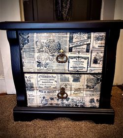 Upcyvled vintage newspaper-themed decoupage paper on the drawer fronts.