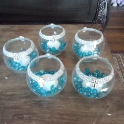 Five Bowls With Blue Rocks In Them Styrofoam In The Middle Ribbon Around With Rhinestones And Crosses On The Front 