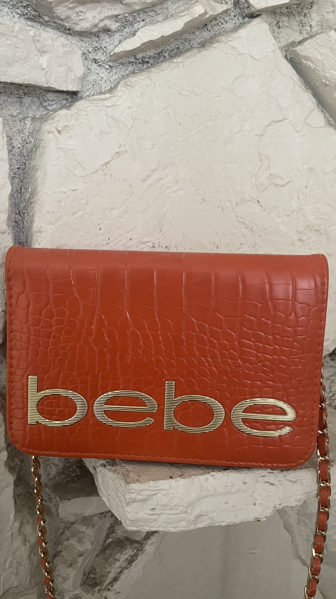 Bebe Leona Fabiola Croco Stamped Vegan Leather Logo Crossbody Clutch Bag in Orange. 