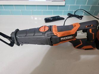 Rigid reciprocating  saw  rigid  battery  brand new  rigid charger   the saw is used but in great shape  charger is used