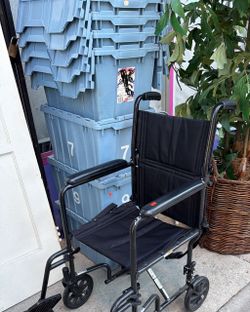 Black Transport Wheelchair with Padded Armrests folds up
