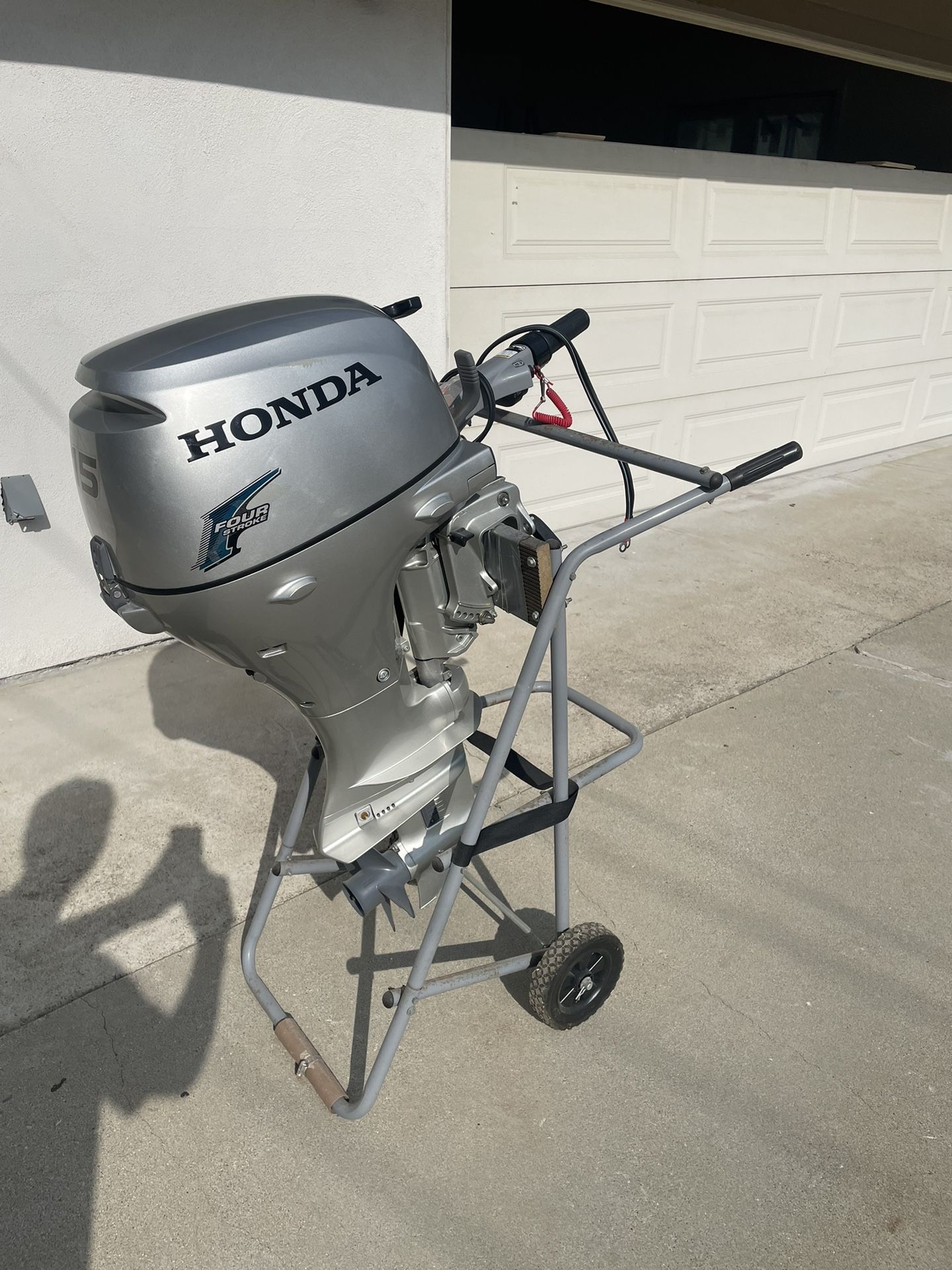 Silver Honda BF20D 4-stroke Outboard Motor With Stand And 3gal Fuel Tank