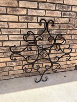 Wrought iron wall art from AptDeco features amber-colored tiles inserts