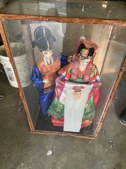 Asian couple dolls in cabinet