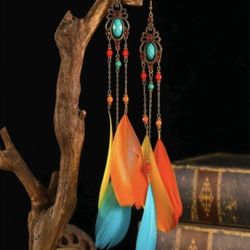 Add a pop of color to your outfit with these stunning multicolored feather earrings! Featuring turquoise stones and beads, these earrings are adorned 