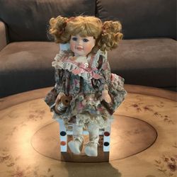 Vintage Porcelain Doll Sitting on a Chair