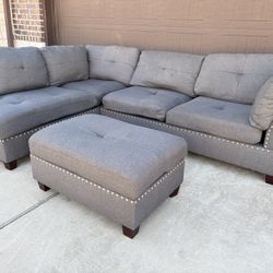 Comfortable gray sectional sofa with matching ottoman and studded detailing. Good condition, sturdy.