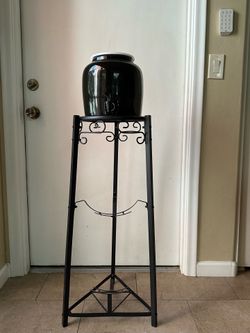 Black ceramic water holder with black wrought iron stand.