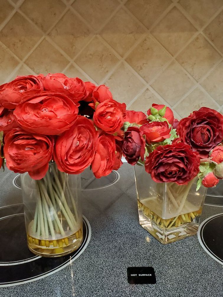 Faux flowers in vases, table decor. Red roses and ranunculus