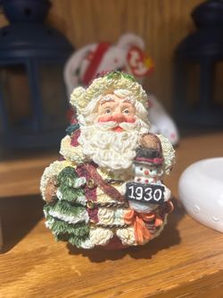 vintage Crinkle Claus Santa figurine by Possible Dreams, featuring Santa holding a Christmas tree and a small snowman with a sign reading "1930" (part