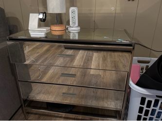 mirrored 3-drawer dresser featuring a glass top and sleek silver metal handles.