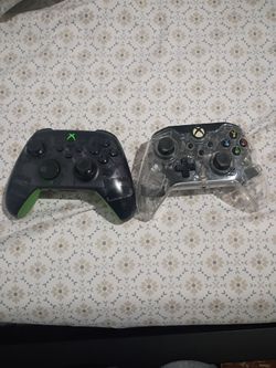 Two Xbox controller the black one is battery and the clear one is wire