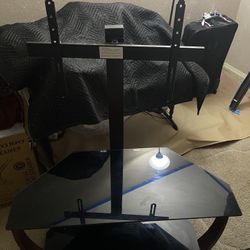  Black  glass and metal TV stand with a built-in swivel mount and cable management system. 