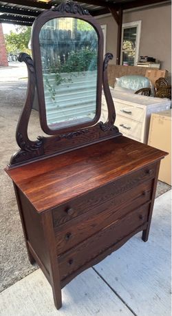 An 1896 late Victorian three drawer dresser with arched tilting adjustable mirror