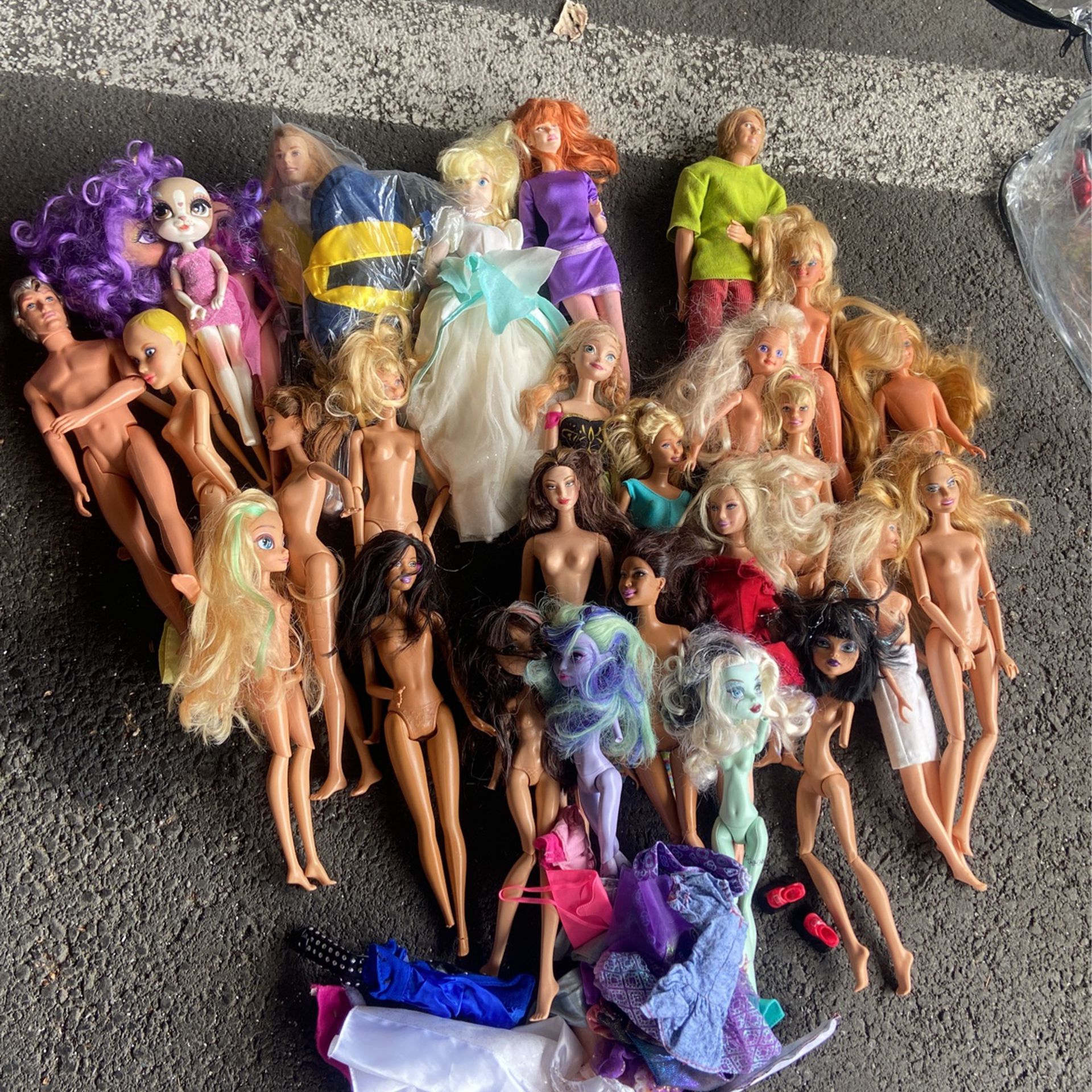 lot of barbie dolls and clothes and monster high