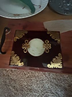 vintage Chinese wood and brass jewelry box featuring an ornate central jade-style medallion and decorative metal corner inlays.