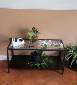 WOOD AND GLASS COFFEE TABLE WITH METAL EDGES.