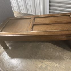  vintage coffee table walnut wood piece featuring  rattan inserts beneath glass panels, designed in a Mid -century modern style.     