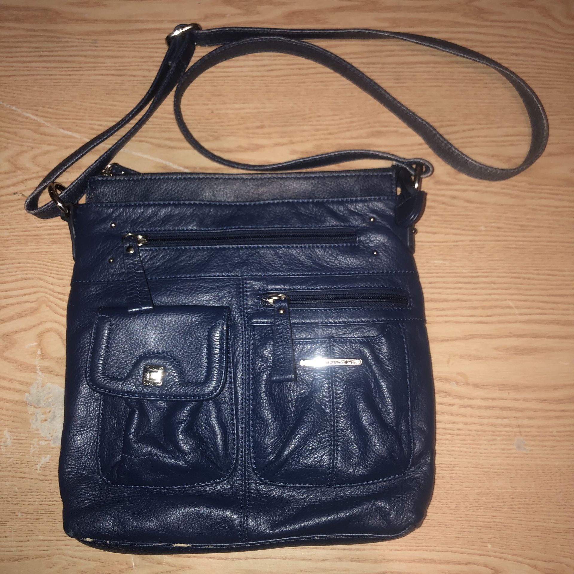 Stone Mountain navy blue leather purse with lots of unique compartments. It does show some wear in a couple places that the letter is faded. Still a