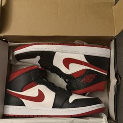 Black and red Jordan 1 mid trainers. 