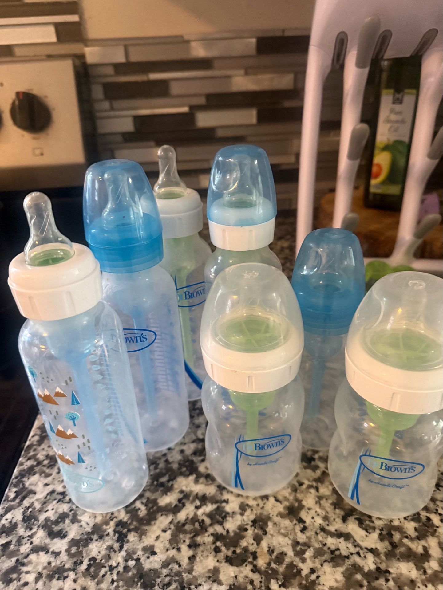 Gently used baby bottles in good condition, along with a bottle rack.