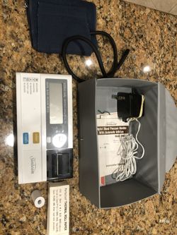 Digital blood pressure meter with printer paper. Battery and wall plug operable.