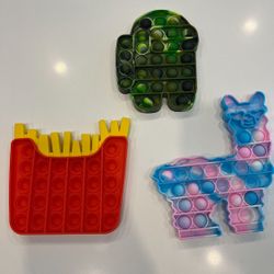 Set Of Pop It Fidget Toys. Llama/Alpaca, French Fries, Among Us Spaceman. French fries, among us space man and lama/alpaca pop it toys. Great for anxi