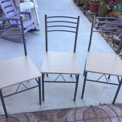 Three identical chairs in good condition, made of metal and wood.
